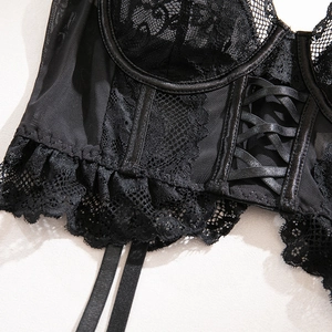 Detailed view of black lace embroidery and satin ribbon lacing on underwire corset bra