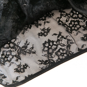 Détail macro de dentelle noire aux motifs floraux avec coutures de finition de qualité