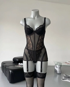 Detailed view of black lace bodysuit with sheer mesh panels and matching stockings
