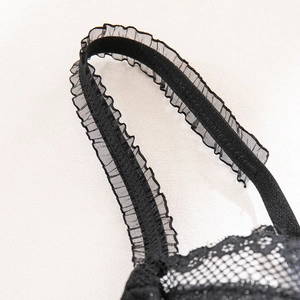 Detailed close-up of adjustable black lace shoulder straps with elegant ruffled tulle edges