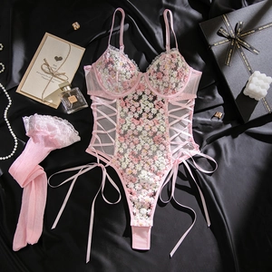 Detailed flat lay of pink floral lace bodysuit with embroidery and lace stockings