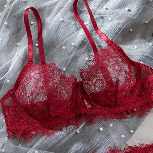 Detailed close-up of red floral eyelash lace fabric and underwire on a sexy bra set