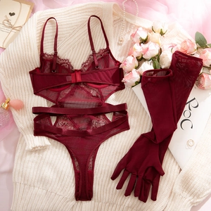 Detail of burgundy lace bodysuit with mesh cut-outs and matching long gloves on flat lay