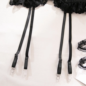 Detailed view of black lace garter belt with adjustable straps and matching leg rings
