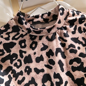 Close-up of leopard print bodysuit featuring a high neck design and knit texture