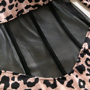 Macro detail of leopard print bodysuit showing mesh panels and corset boning structure
