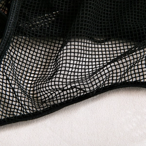 Detail shot of black mesh fabric with reinforced stitched edges and square pattern