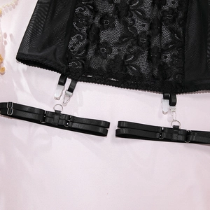 Detail von schwarzen Blumen-Spitzen-Strapshaltern mit Metallclips und Netzstoff