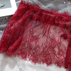 Close-up of red floral eyelash lace with sheer mesh and metal adjustment buckle detail
