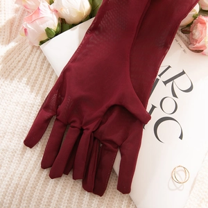 Detailed macro view of dark red sheer mesh gloves with delicate grid texture for events