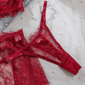 Close-up of deep red lace lingerie set with eyelash trim and metal buckle detail
