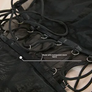 Close-up detail of sheer mesh fabric with lace-up straps and metal rings on a black bodysuit