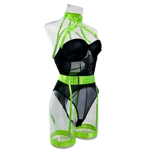 Detail view of black mesh bodysuit with neon green body harness and metal buckles