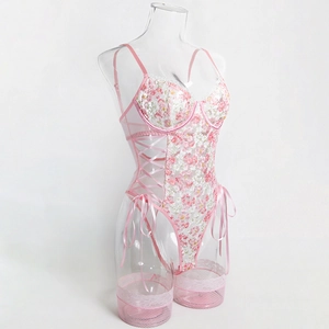 Detail of pink floral lace bodysuit with side lace-up and garter attachments