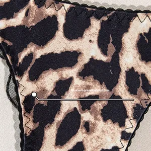 Detailed macro view of leopard print fabric with black lace trim and zigzag stitching
