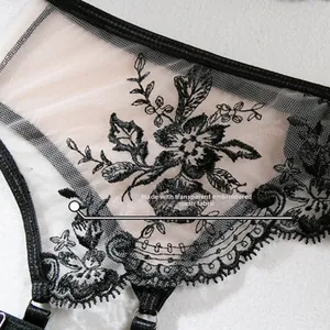 Detailed close-up of black floral embroidery on transparent mesh lingerie fabric