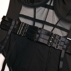 Detailed macro view of black mesh bodysuit showing metal buckles and crisscross straps