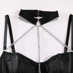 Détail d'un body noir sexy avec chaînes en métal argenté et tour de cou réglable