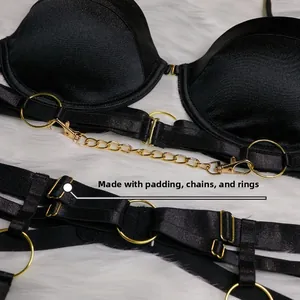 Gros plan sur le body noir avec chaînes dorées et bonnets rembourrés style punk
