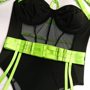 Detail of sheer black mesh bodysuit with vibrant neon green adjustable buckled waist straps