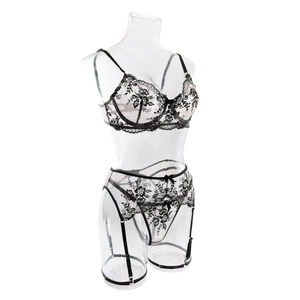 Detailed view of black floral embroidery on white mesh of this 3-piece lingerie set