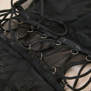 Detail of sheer black mesh bodysuit with metal rings and decorative crisscross lace-up straps