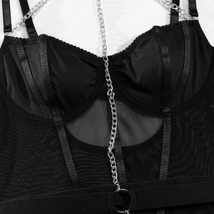 Détails d'un body en maille noire avec chaînes argentées et structure en satin brillant