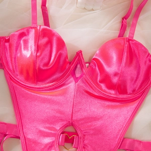Detail of rose pink satin bodysuit featuring underwire cups and a gold heart buckle