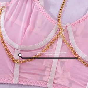 Detail aus pinkfarbenem Netzgewebe mit goldenen Metallketten und Satin-Paspelierung