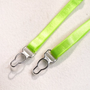 Detail of neon green elastic straps with rib texture and silver metal garter clips