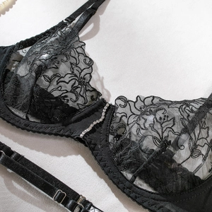 Detailed view of floral lace bodysuit featuring rhinestone heart and metal strap adjusters