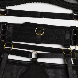 Détail de lingerie en résille noire avec anneaux métalliques dorés et sangles