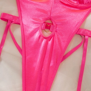 Close-up of neon pink metallic bodysuit featuring a gold heart-shaped ring detail