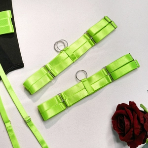 Detail of neon green elastic straps with silver metal rings and adjusters for lingerie