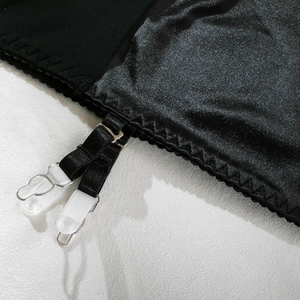 Detail of black satin and mesh dress with adjustable straps and silver metal buckles