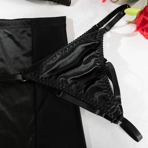 Detail view of black satin lingerie with pleated edges and adjustable elastic straps
