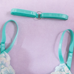 Detail of mint green lace lingerie with delicate floral embroidery and adjustable strap