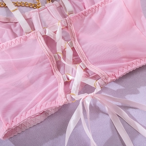 Detailaufnahme von rosa Netzstoff mit Satin-Überkreuzbändern und goldenen Metallringen
