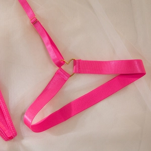 Detailed close-up of neon pink lingerie straps featuring a golden heart metal buckle