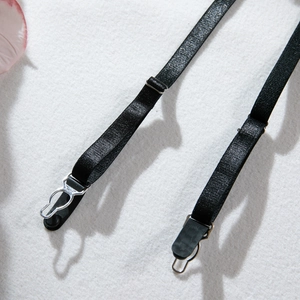 Detail of adjustable black elastic garter straps with metal buckles and clips for lingerie