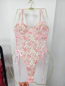 Detailed view of pink floral embroidery and side ribbon lacing on the bodysuit
