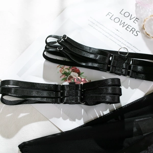 Close-up of black elastic leg garter with metal ring detail and mesh fabric texture