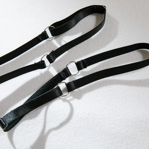Detail of adjustable black elastic lingerie straps with metallic rings and sliders