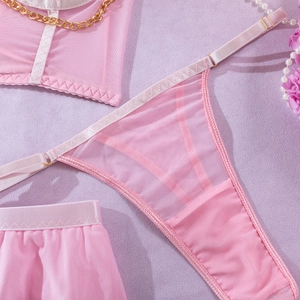 Detaillierte Nahaufnahme von rosa Mesh-Lingerie-Set mit goldenen Ketten und Spitzenstruktur
