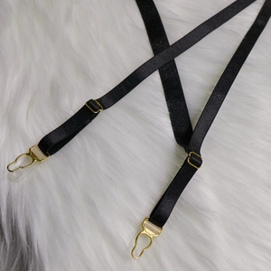 Détail de la jarretière élastique noire avec boucle de réglage et clip en métal doré