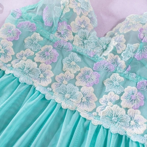 Macro shot of mint green floral embroidery and pleated mesh texture on women lingerie