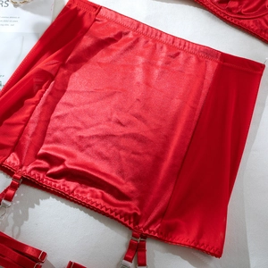Detail of red satin and mesh garter belt with metallic buckles and serrated stitching