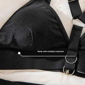 Détail du haut de lingerie noir avec anneaux métalliques et textures de tissus brillants