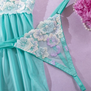 Close-up of light blue mesh dress with intricate white and purple floral embroidery details