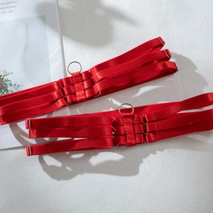 Detail of red satin elastic straps with adjustable metal buckles and rings for leg harness
